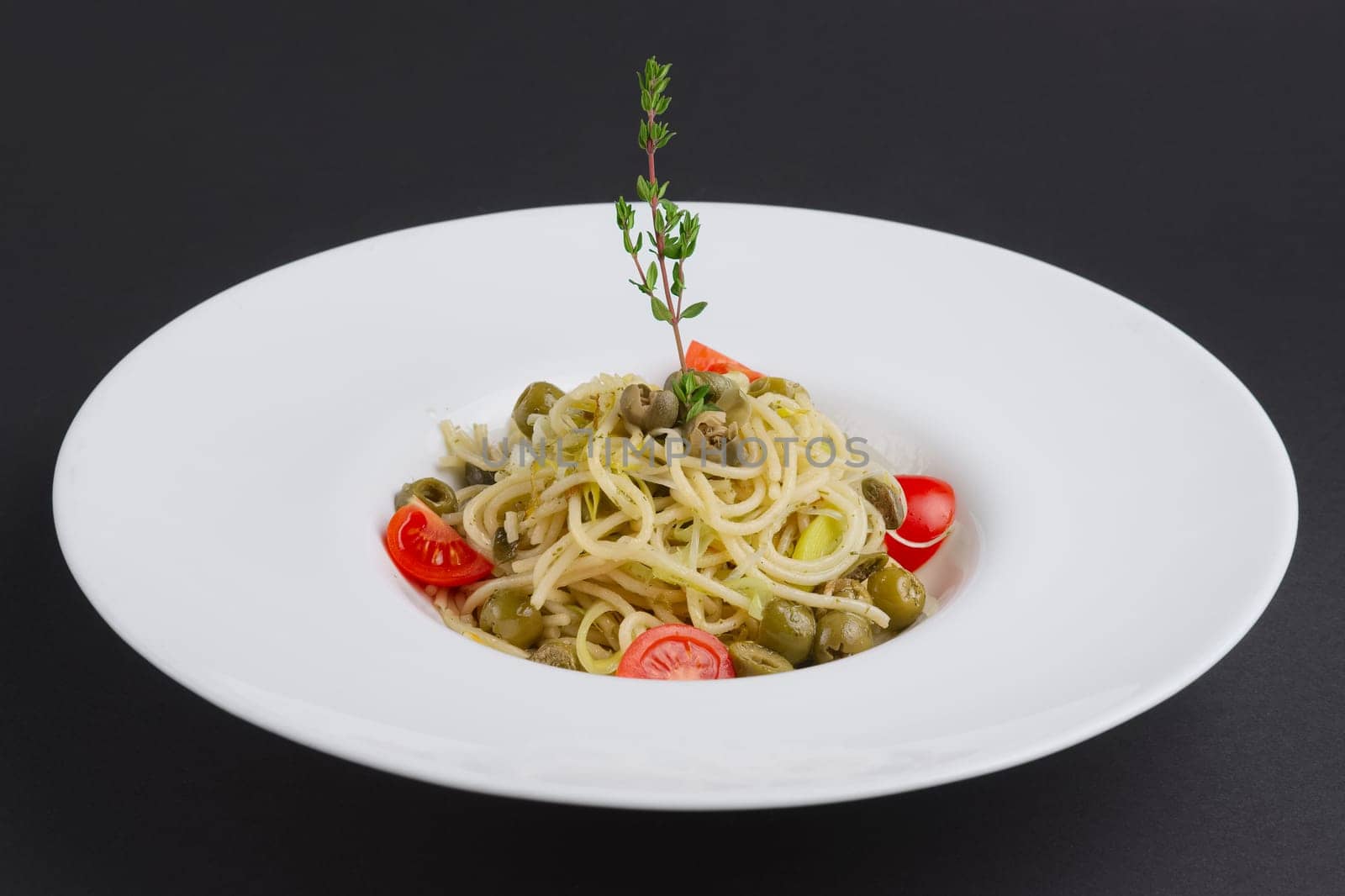 Traditional lenten spaghetti with shallot, tomato, rosemary and olives on a plate