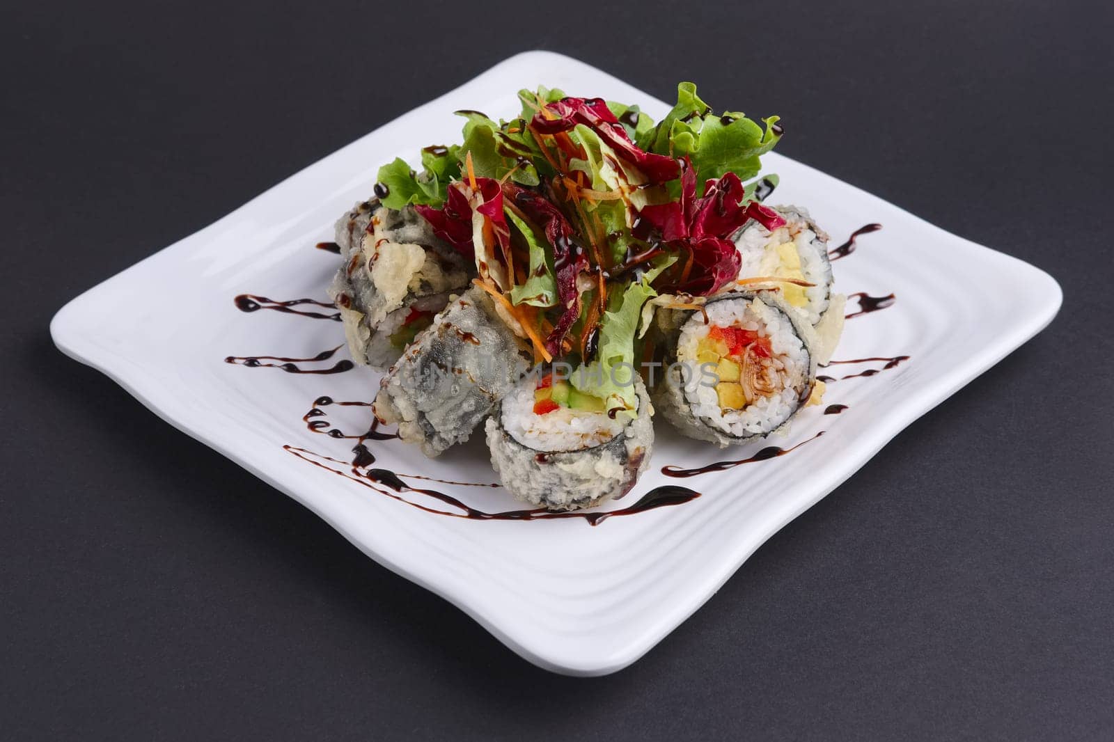 Spring rolls in omelet with fresh salad and spicy caramel sauce