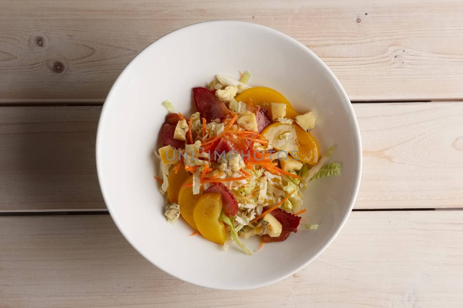 Portion of salad with bacon, cabbage, tomato and blue cheese, top view