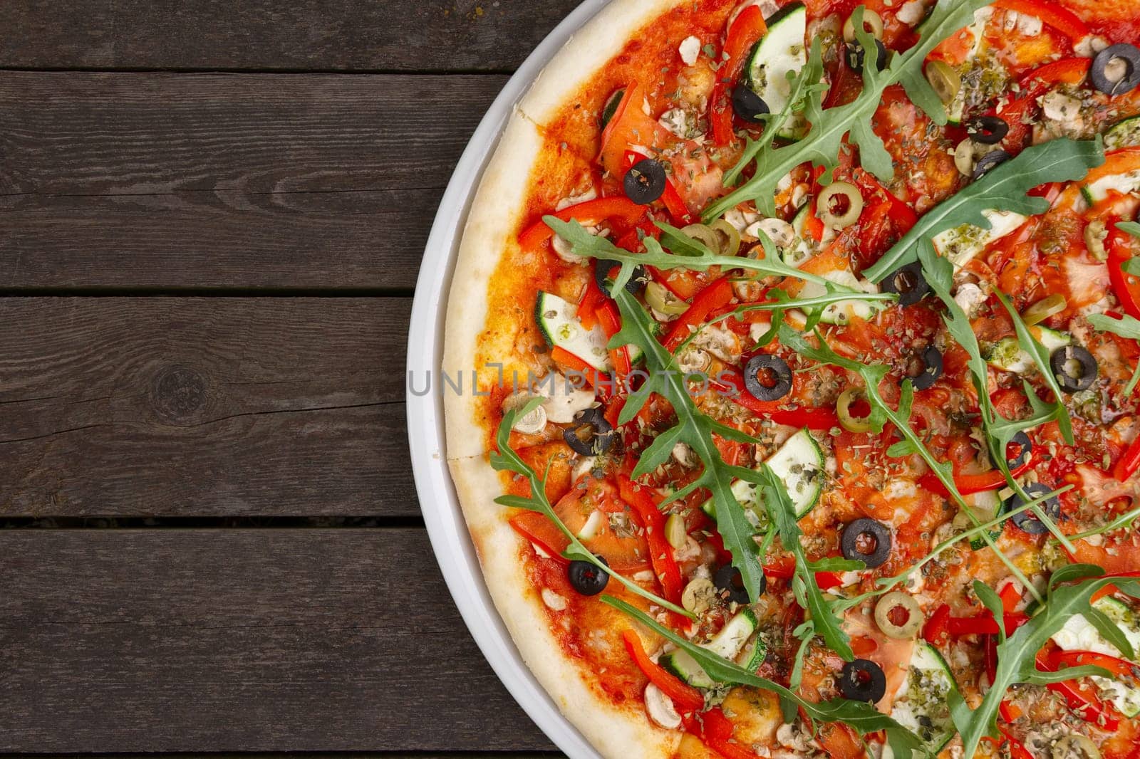 Lean pizza Margherita with cheese, arugula, tomato sauce on a white plate. Your text here.