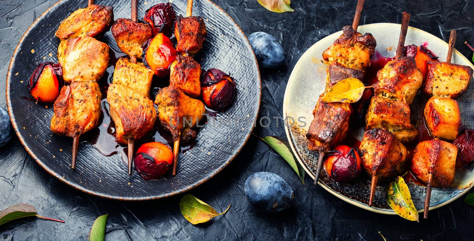 Fried meat on wooden skewers.Tasty kebabs in plum sauce