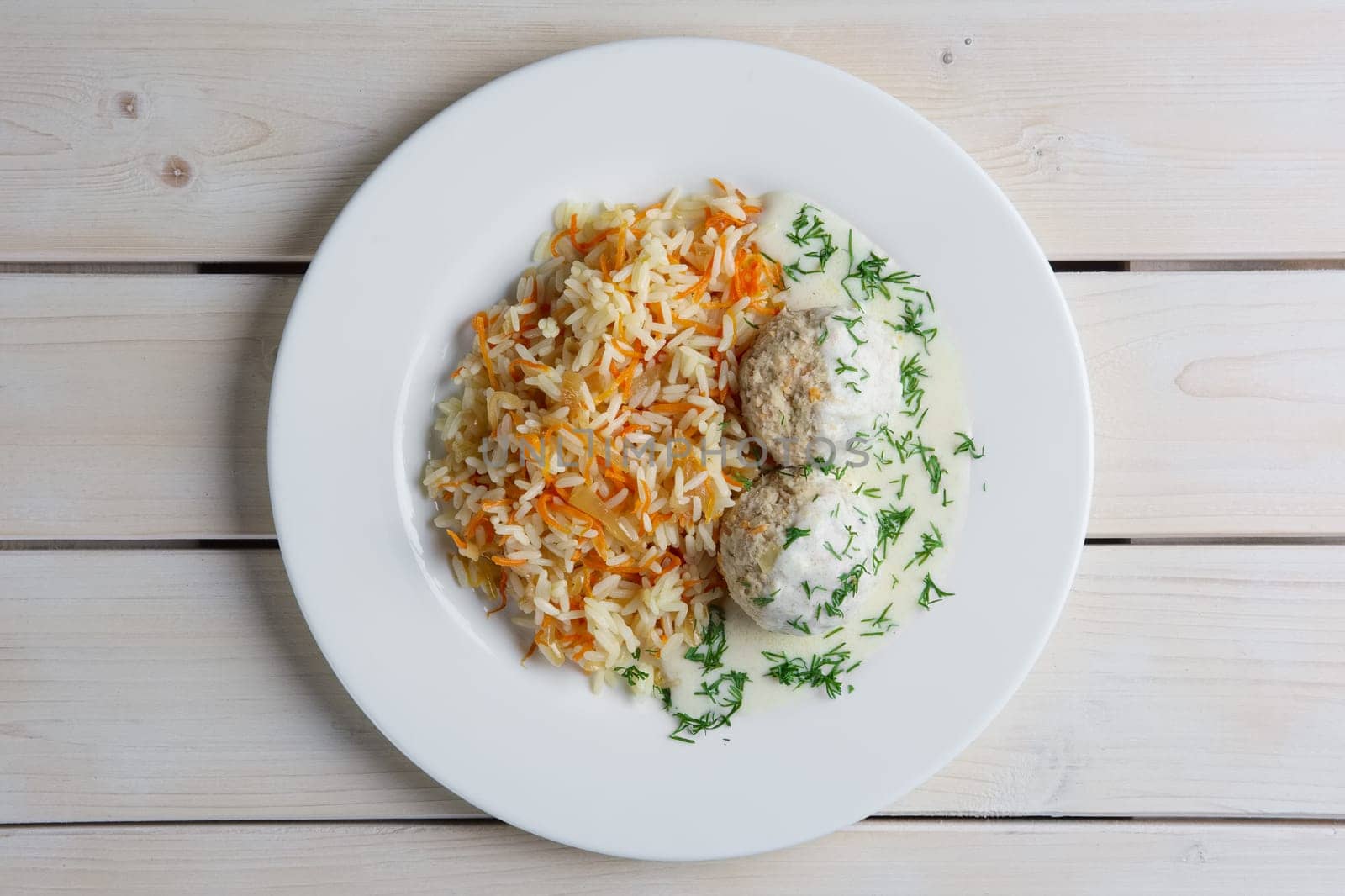 Top view of plate with meatballs with rice and carrot.