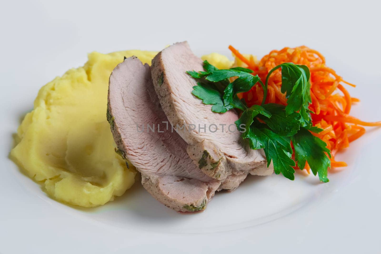 plate with oven made pork with mashed potato and spicy carrot