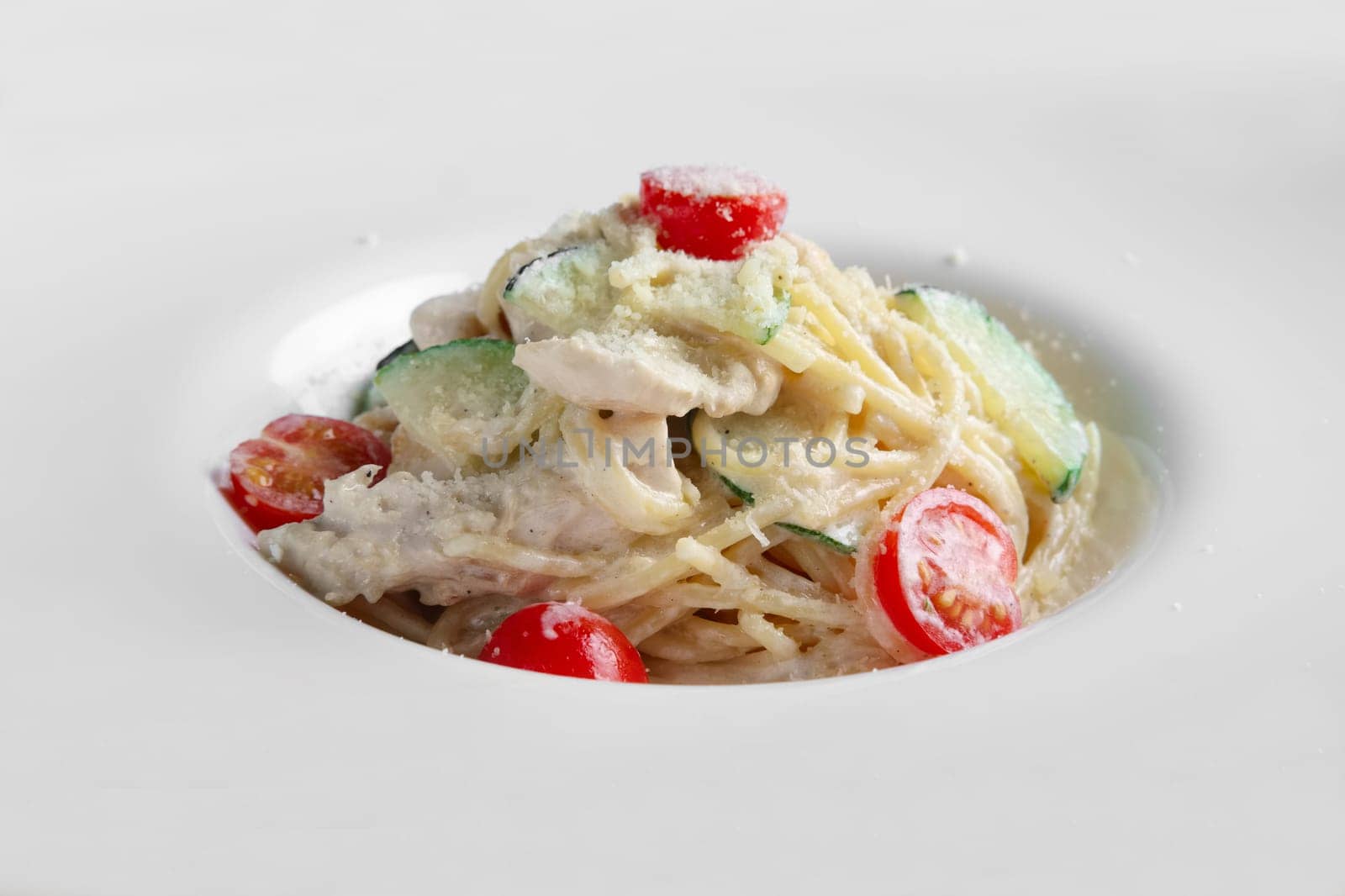 Close-up view of pasta with chicken, tomato and cucumber