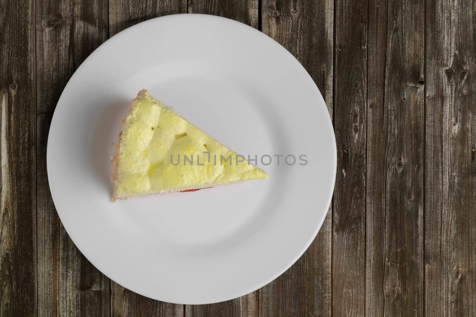 Top view of cherry cake with whipped cream on wooden table