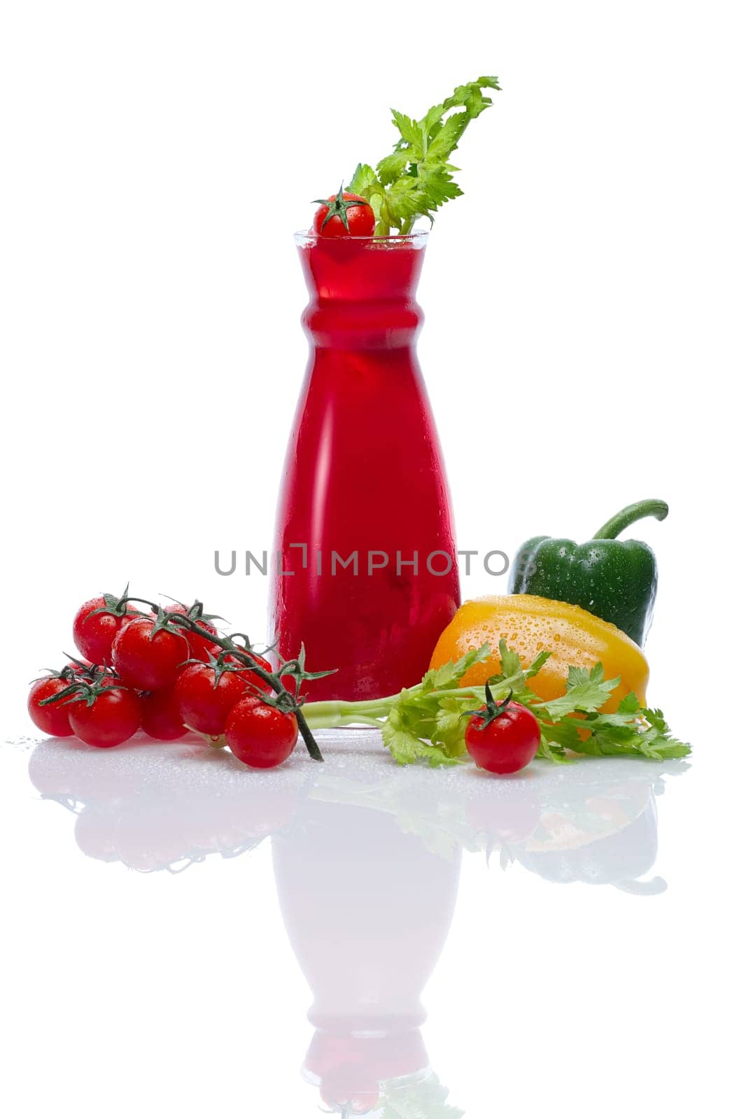 Cold drink with tomato, paprika and celery in jar with water drops.