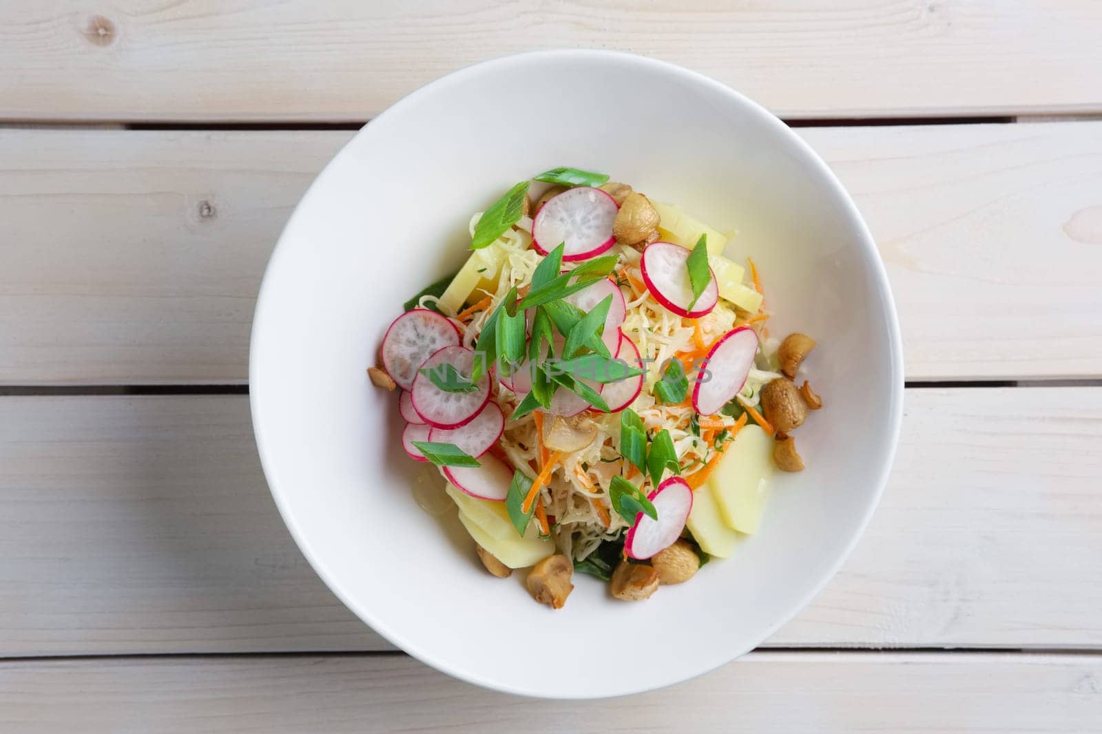 Salad with radish, cabbage, mushroom and potato. Top view.