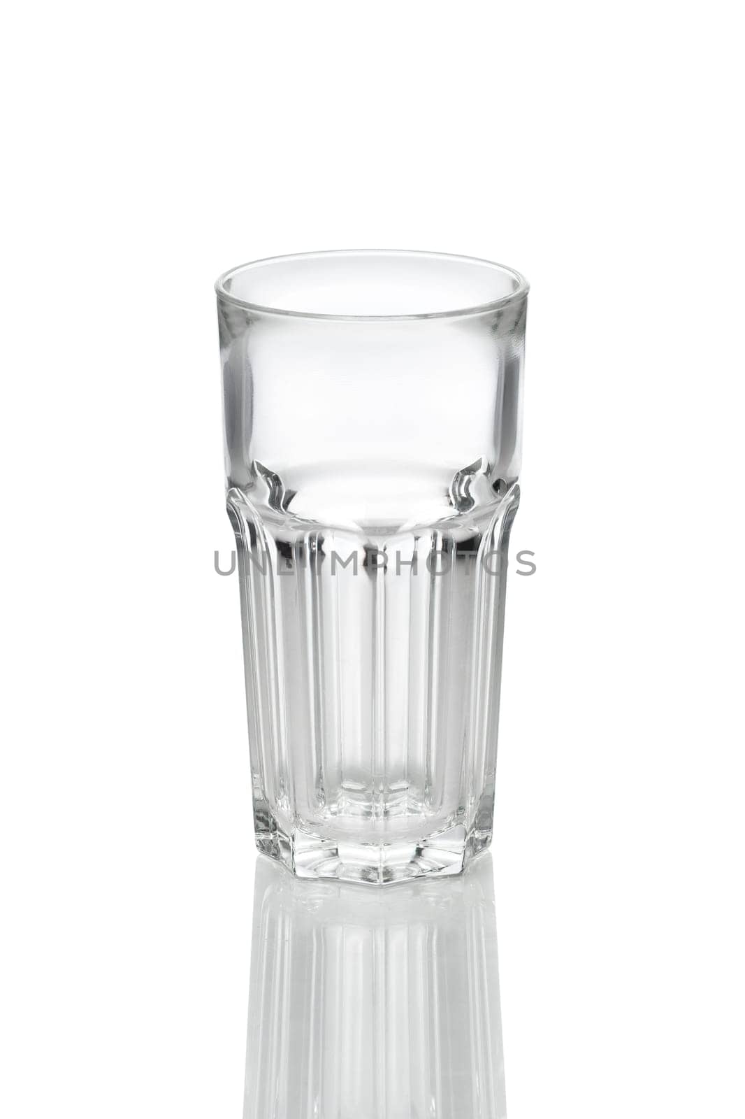 Empty transparent faceted glass with reflection on white background.