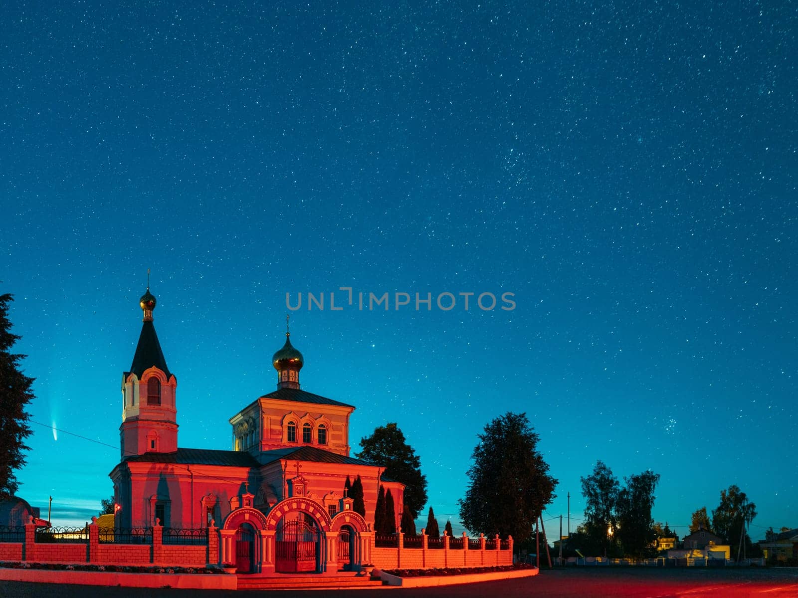 Korma Village, Dobrush District, Belarus. Comet Neowise C2020f3 In Night Starry Sky Above St. John The Korma Convent Church In Korma Village. Famous Orthodox Church And Historic Heritage.