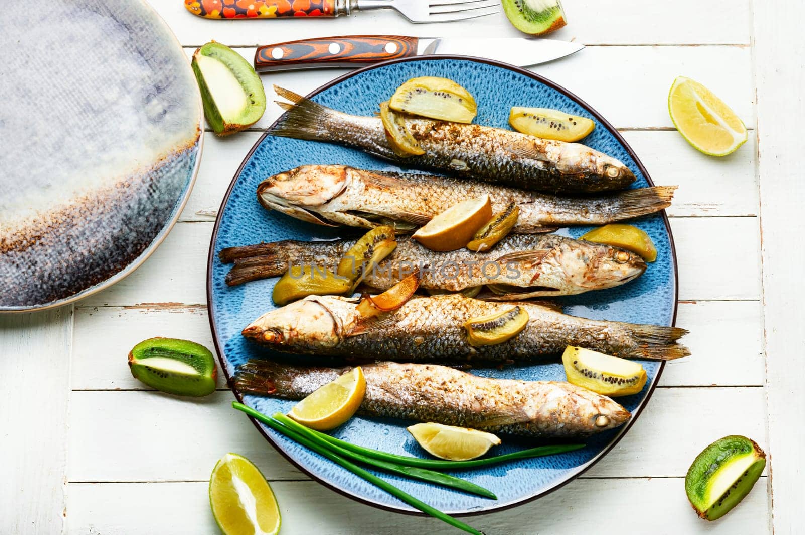 Delicious baked pelengas, fish with kiwi and lime.