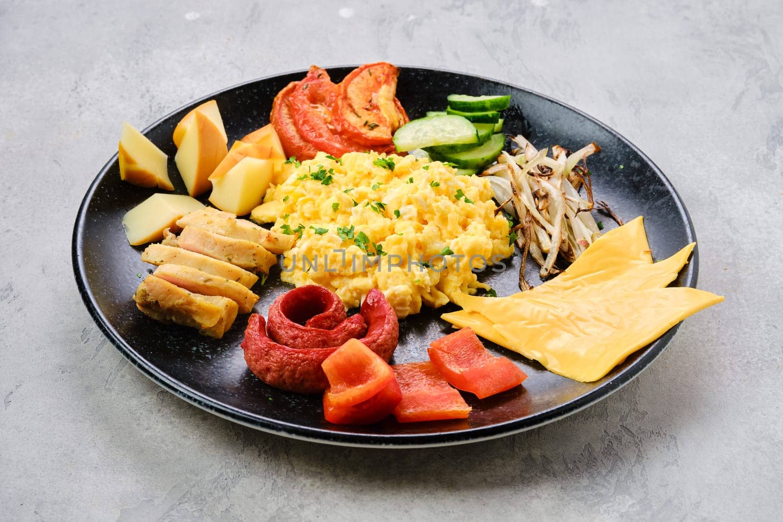 Scrambled eggs with various sausages, cheddar cheese, bell pepper and roasted onion