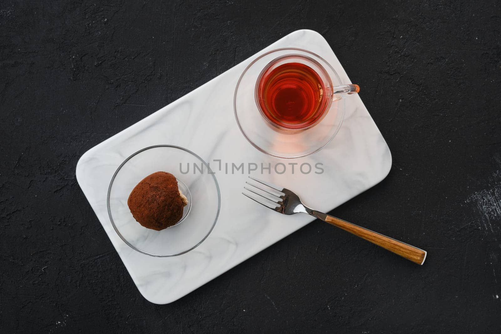 Top view of chocolate biscuit dough cake and a cup of tea on a table