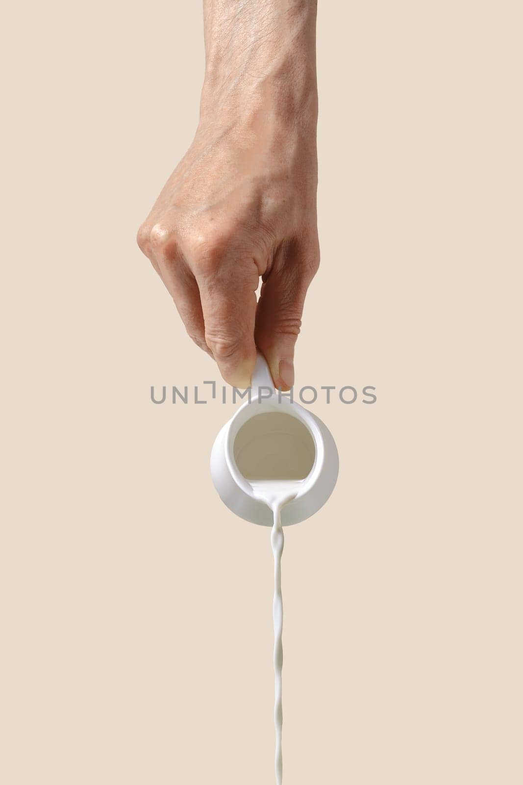 Hand holds milk pot and pouring it