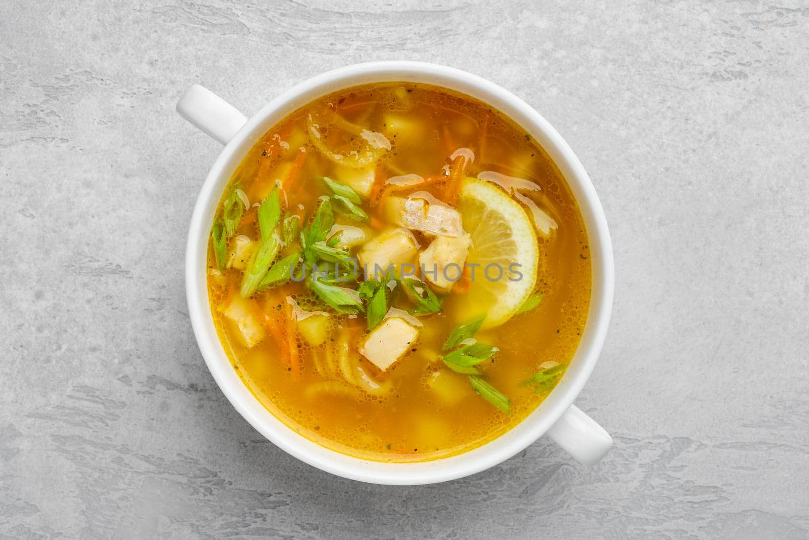 Top view of vegetable and fish soup with fresh scallions