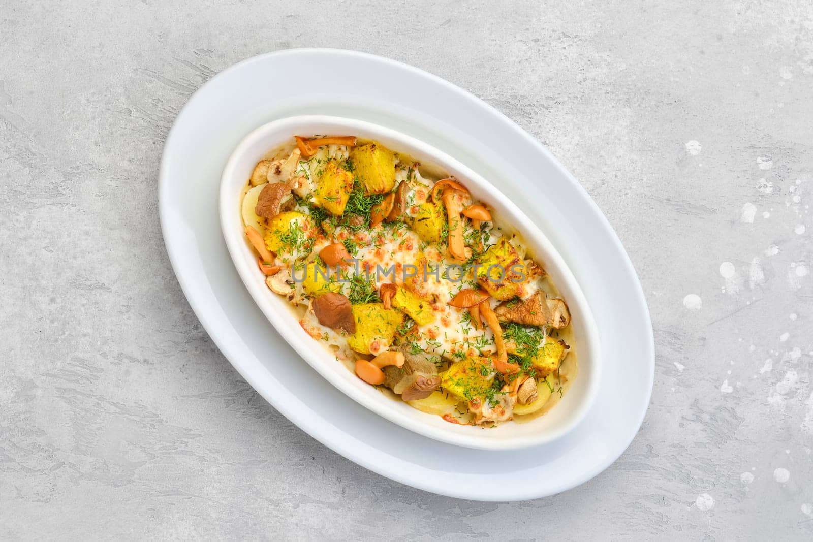 Overhead view of hot casserole with honey agarics, pumpkin and potatoes