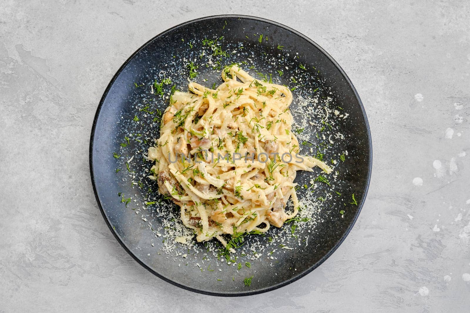 Top view of pasta with honey agarics, onion and cheese on a plate