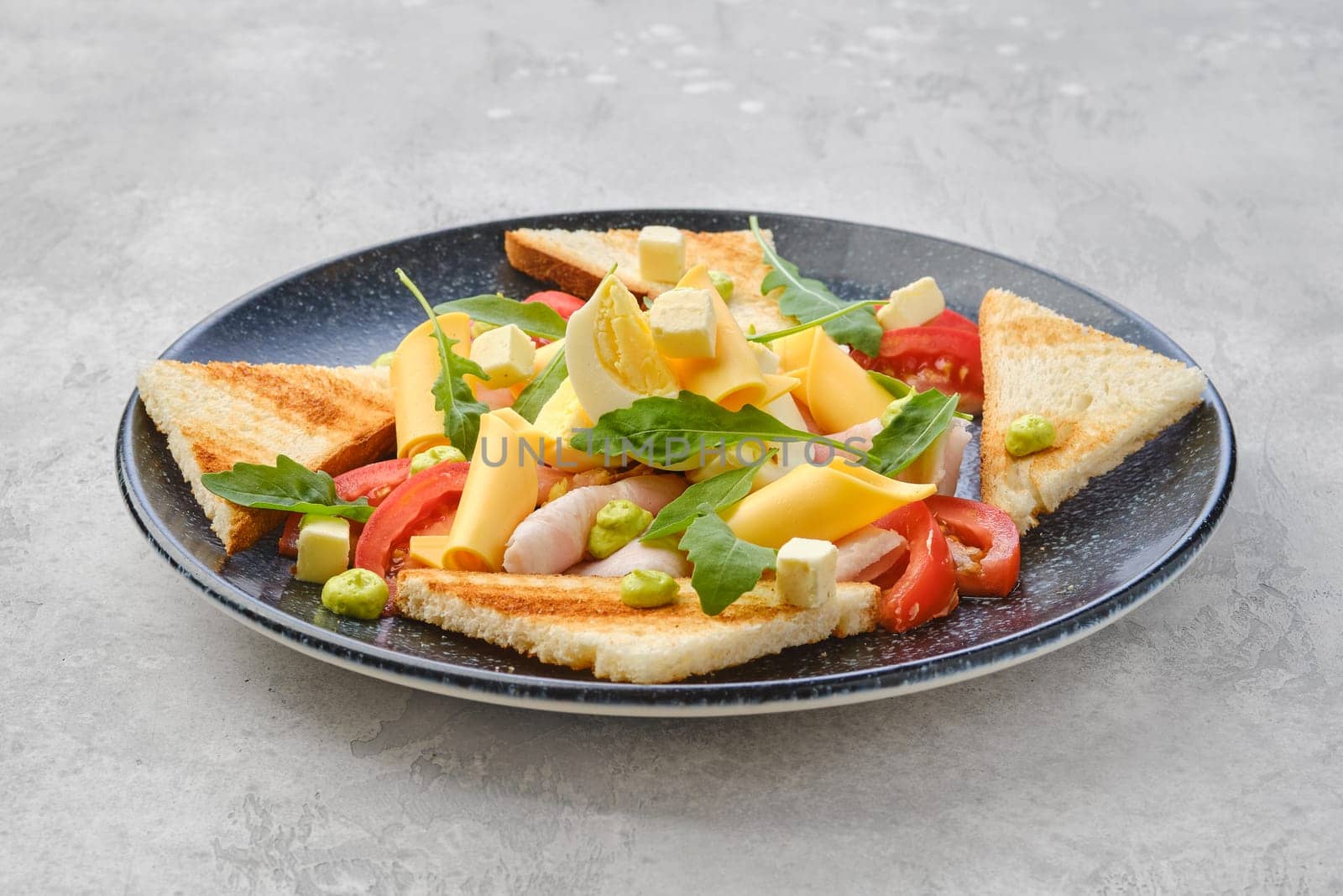 Triangular pieces of toast, ham, boiled egg, cheddar and tomato