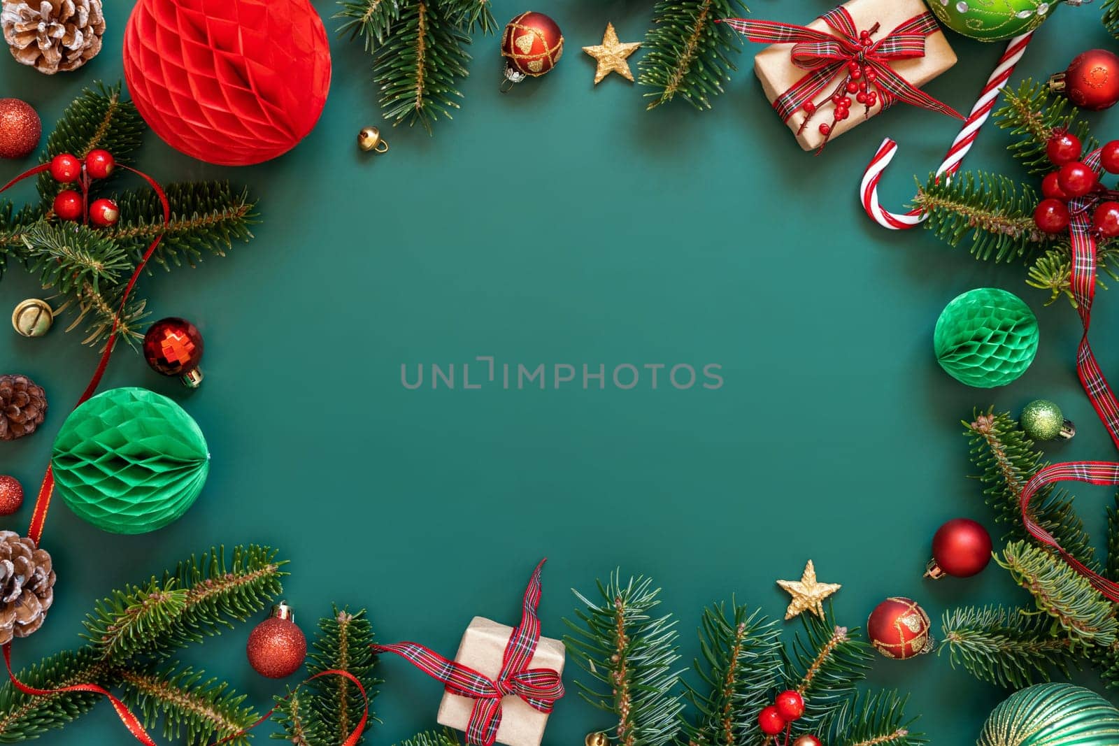 Border made of Wrapped gift boxes, Christmas decorations and green fir branches top view on green background, copy space. Christmas or New Year Holiday atmosphere flat lay