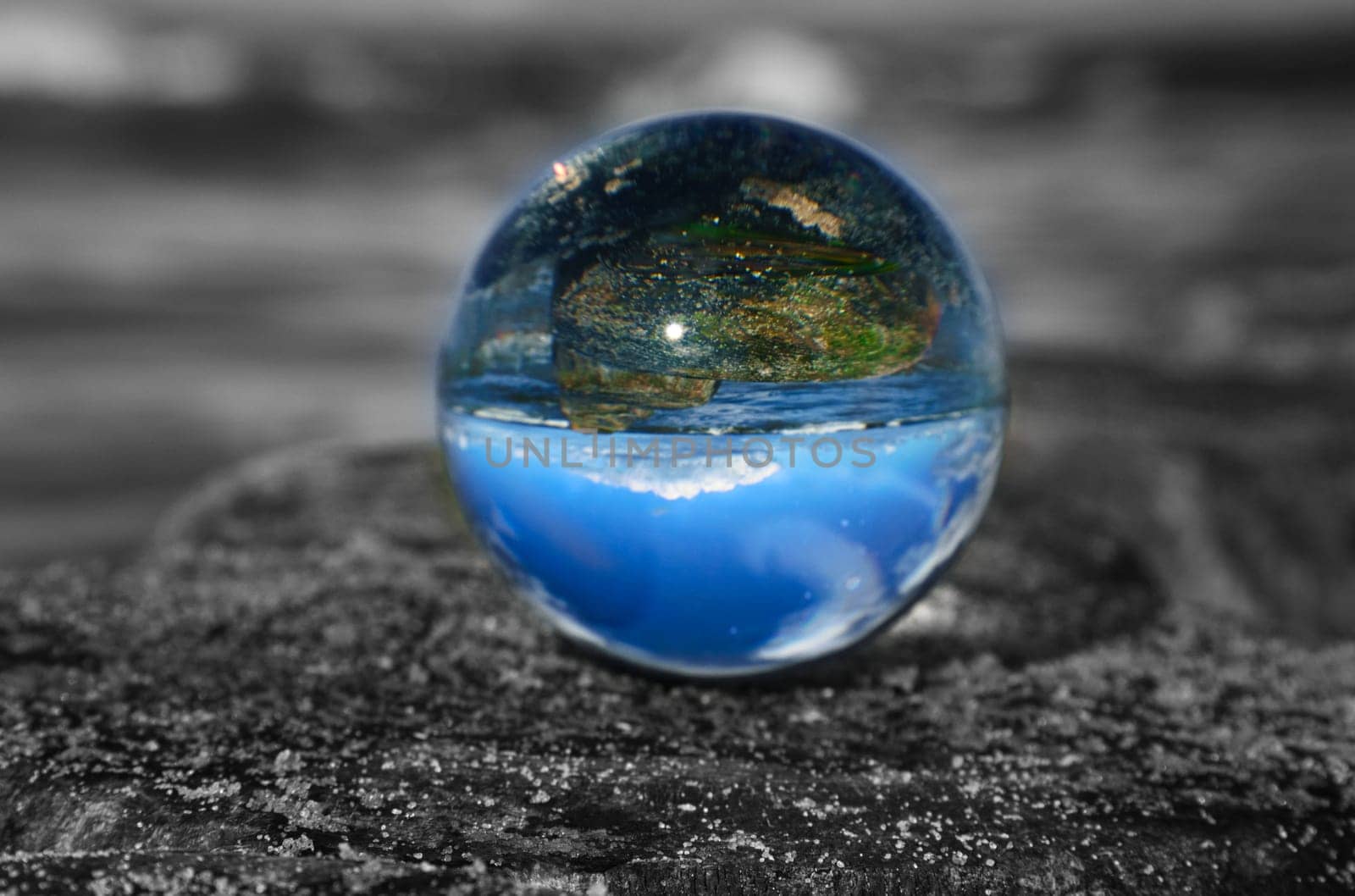 glass globe on the beach of the baltic sea. Black and white photo with a color glass ball