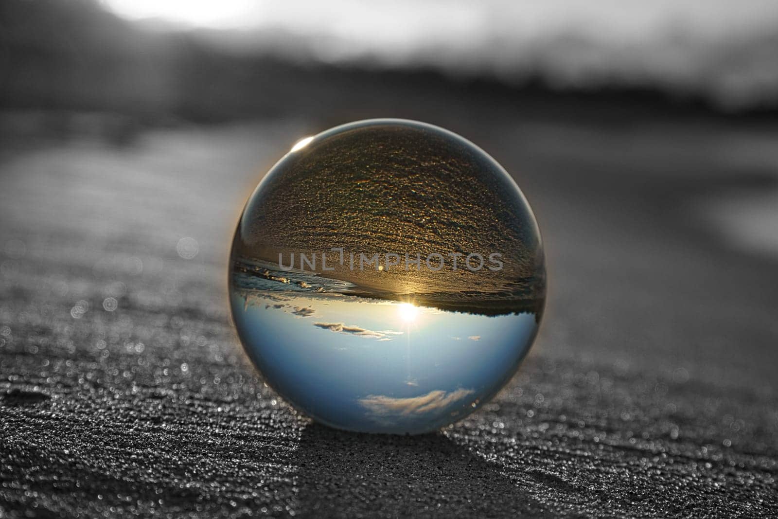 Glass globe on the beach of the Baltic Sea in Zingst in which the landscape is depicted. The surroundings are depicted in black and white, only in the glass sphere reflect the colors of nature