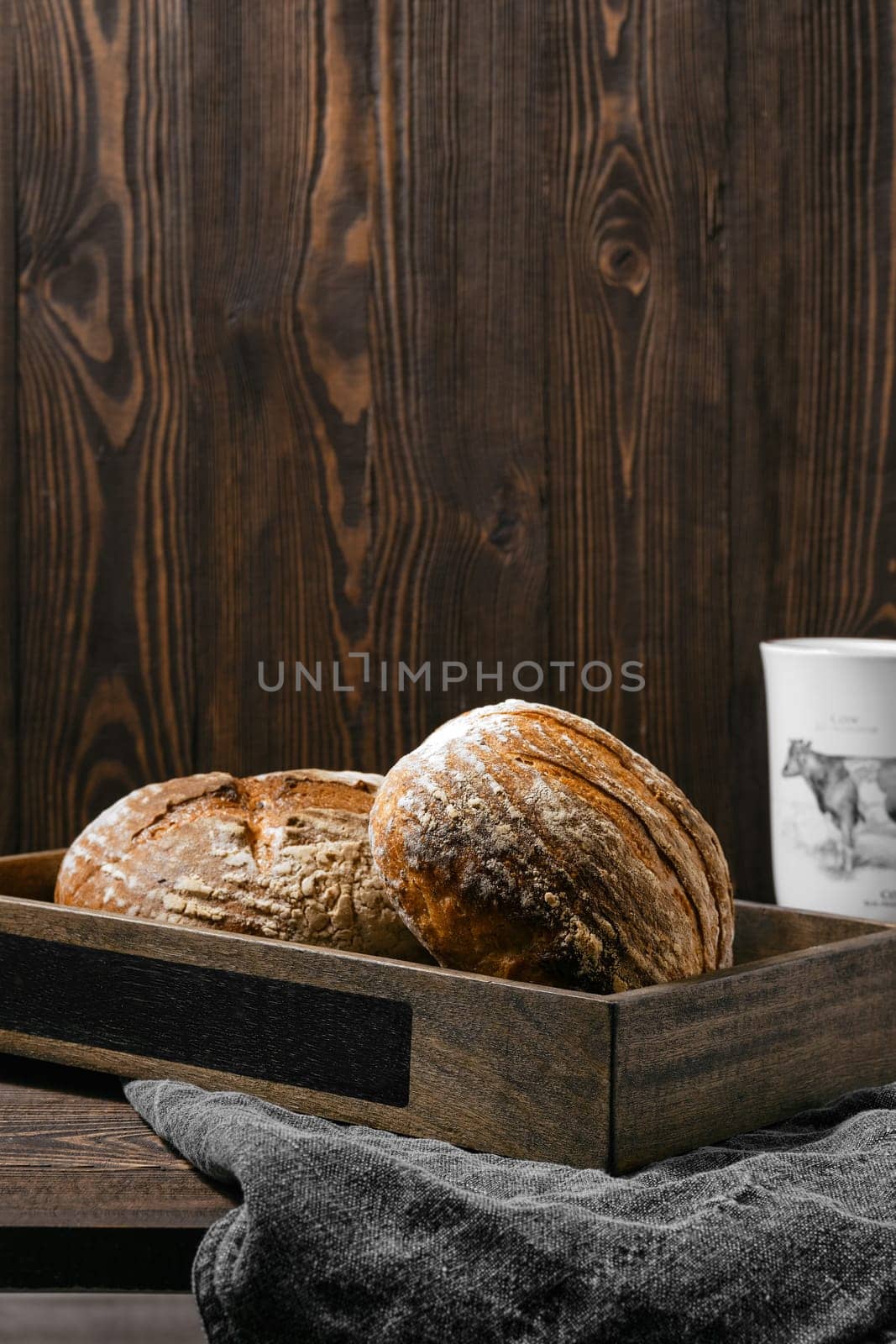 Two loafs of artisan whole grain wheat bread on wooden table
