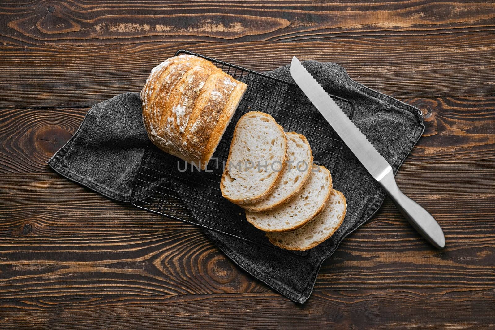 Overhead view of artisan whole grain wheat bread cut on slices on wooden table