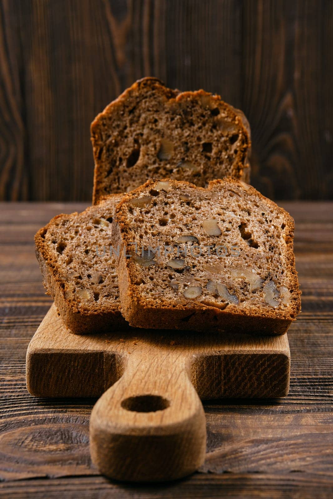 Closeup view of biscuit cake with walnut on wooden board