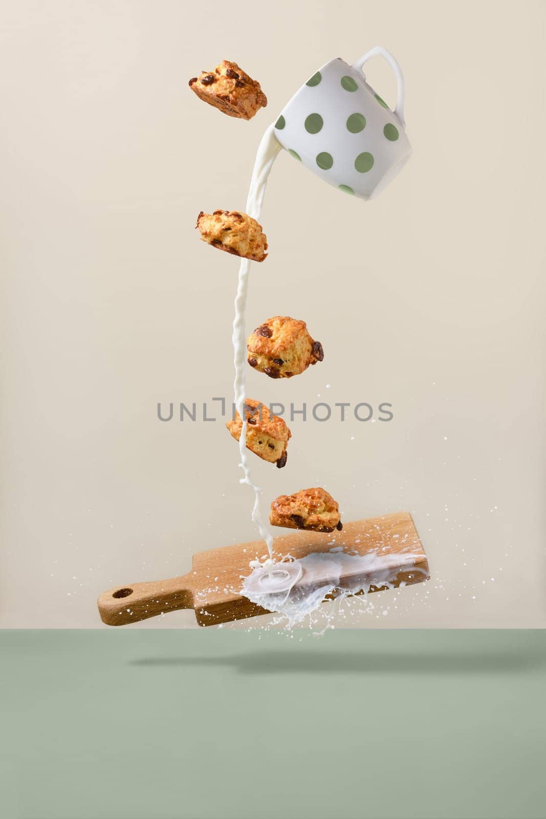 Balancing cookies over wooden board and milk flowing out of the cup