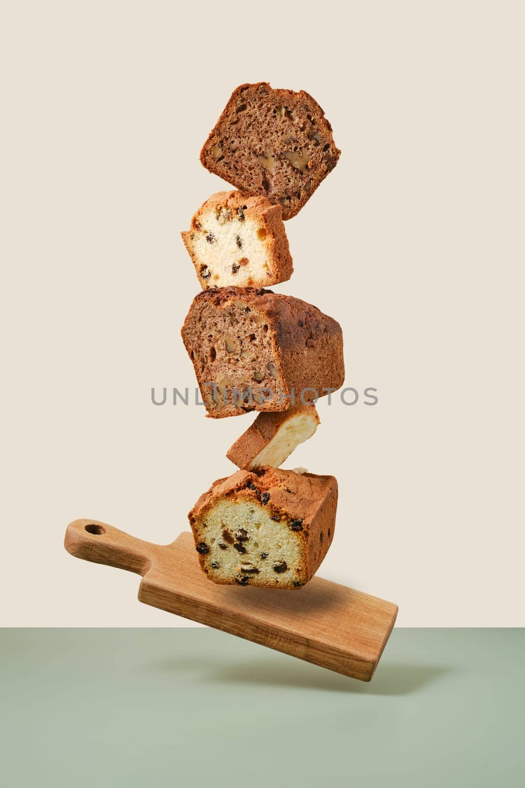 Stacked pieces of biscuit cupcakes. Balancing cakes on wooden board