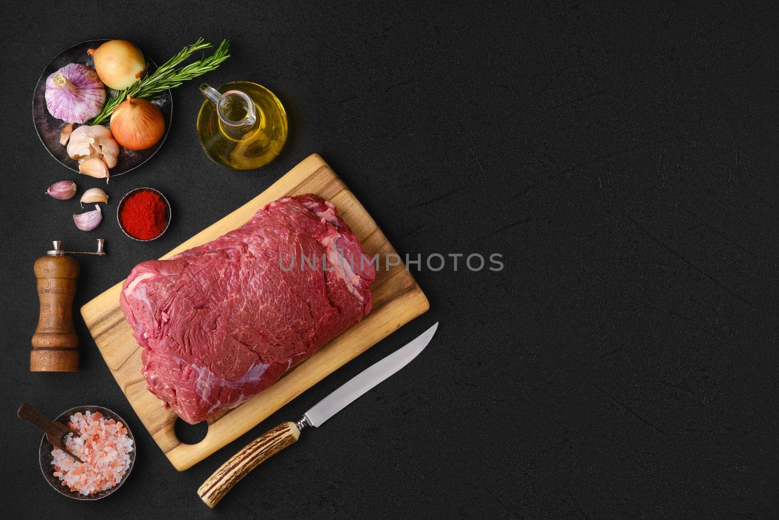 Overhead view of raw chuck eye roast with ingredients for cooking