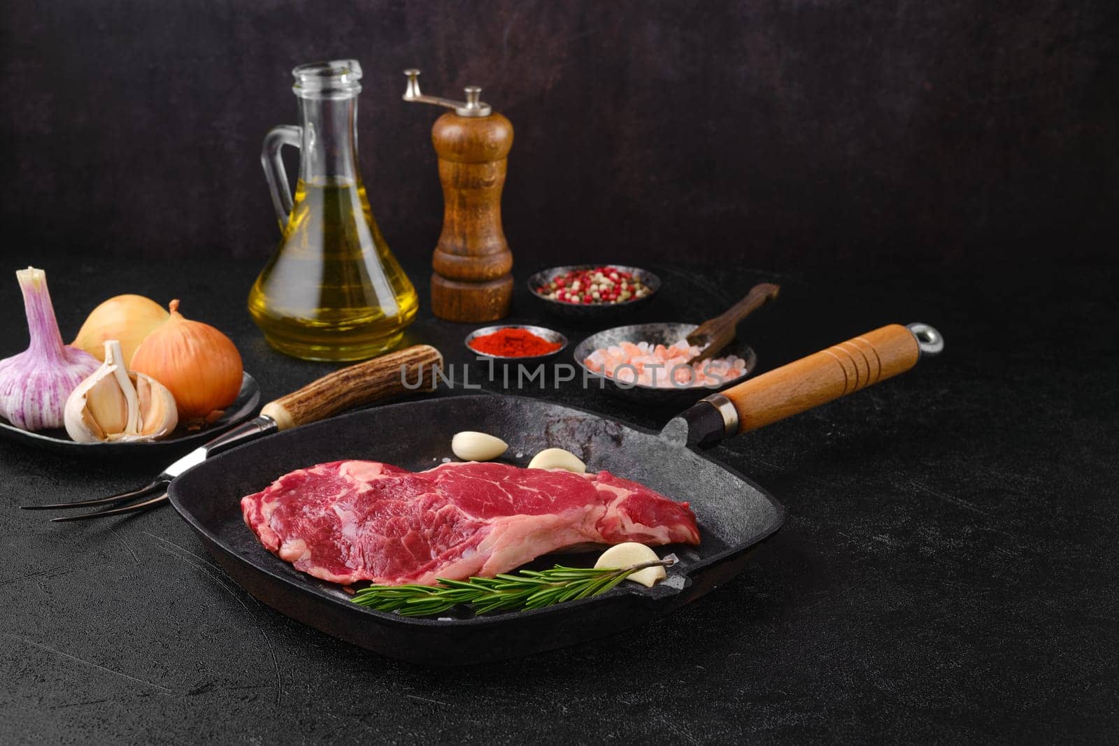 Raw ribeye steak, premium beef boneless meat on cast-iron pan