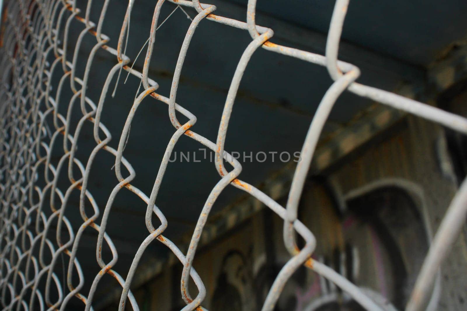 Rusty metal mesh close-up on the background of painted walls.