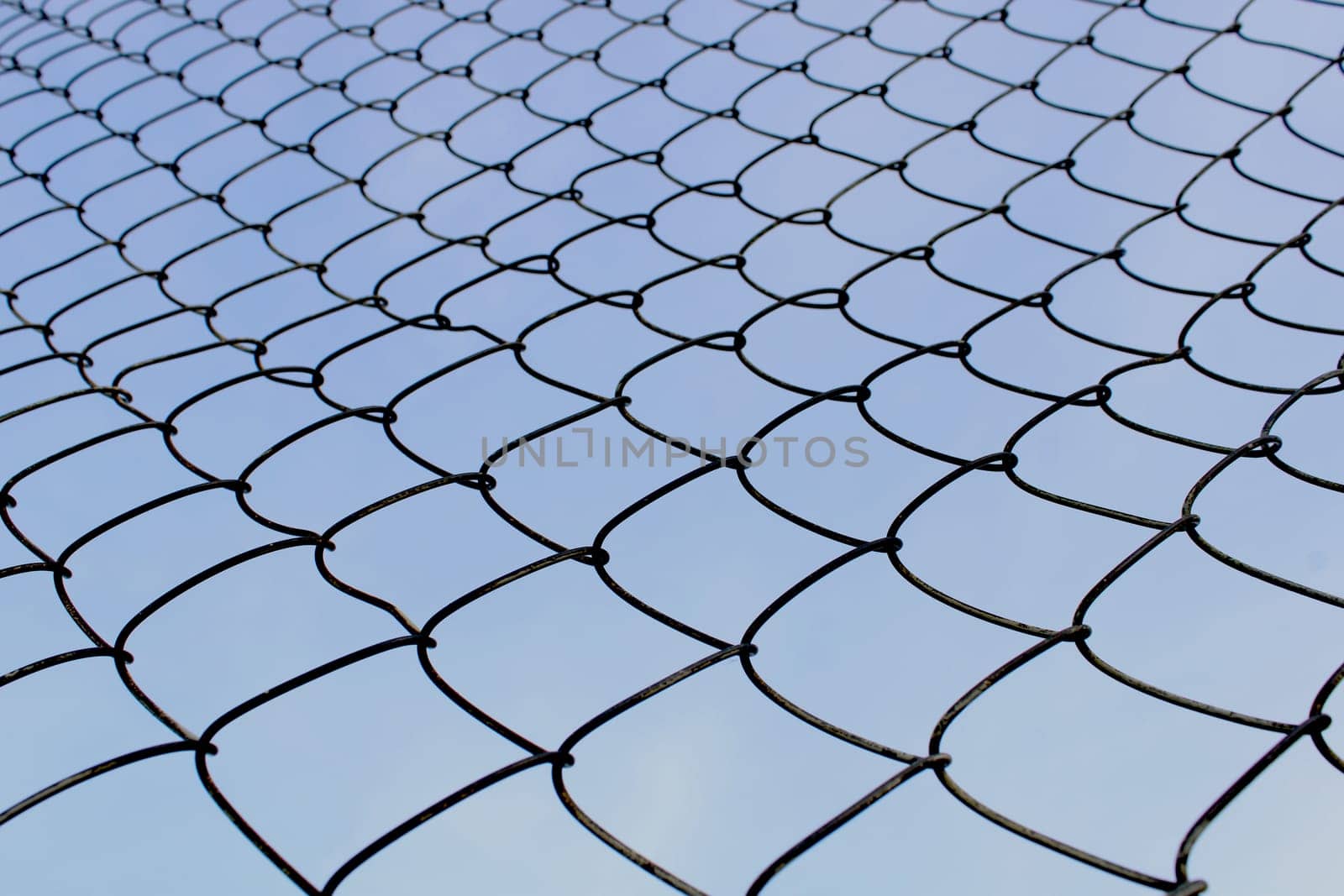 Metal mesh close-up against the blue sky. The concept of freedom and peace.