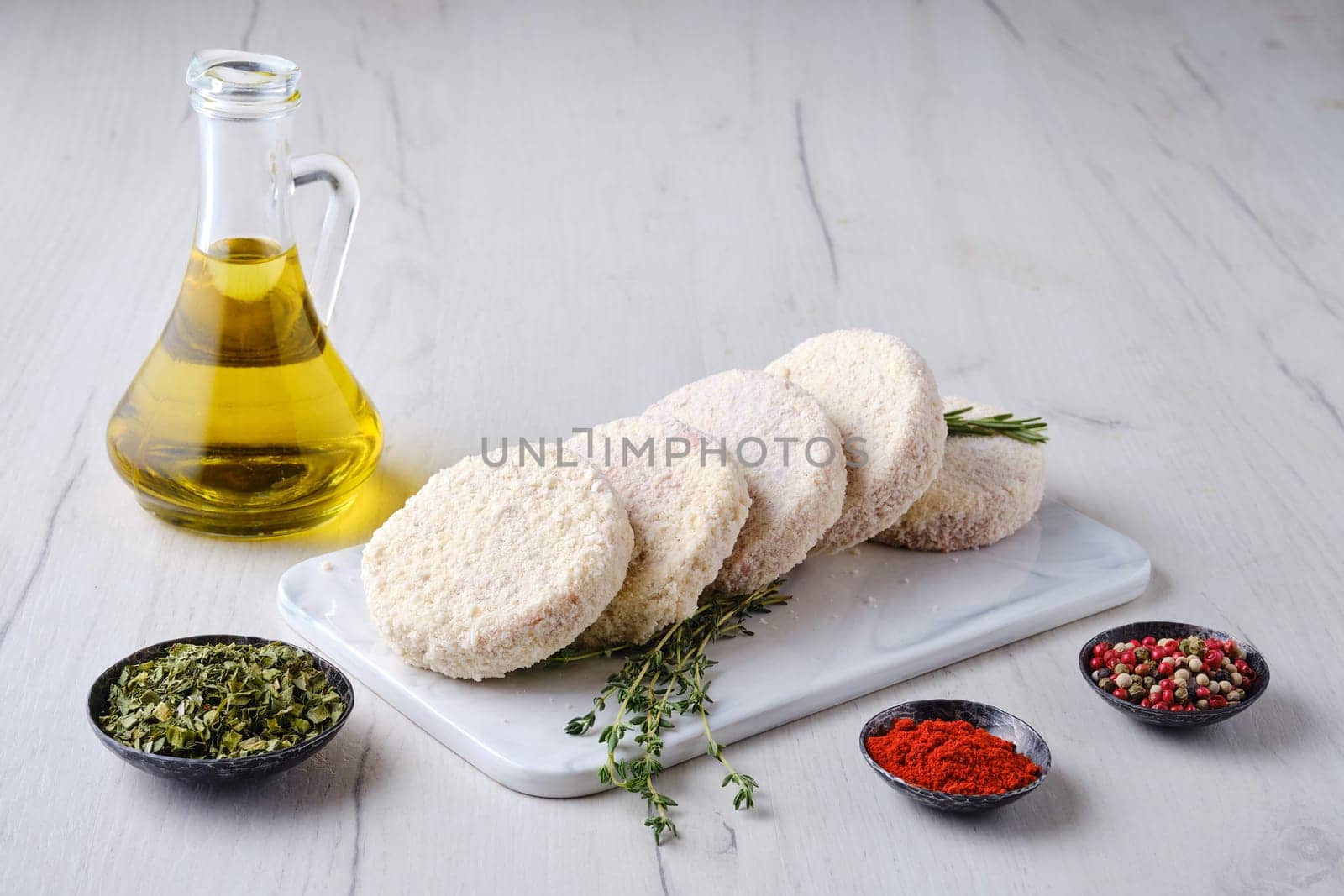 Semifinished beef patties in breading on a kitchen table