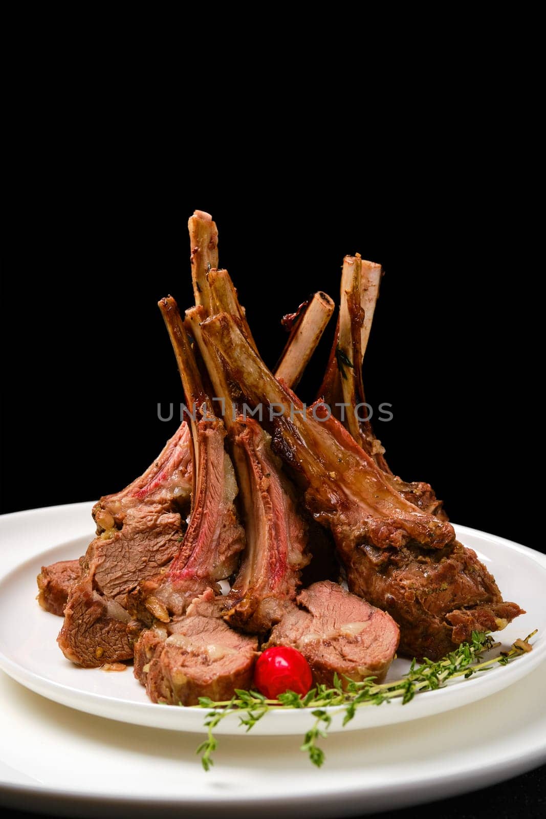 Grilled rack of lamb on a plate with spicy sauce