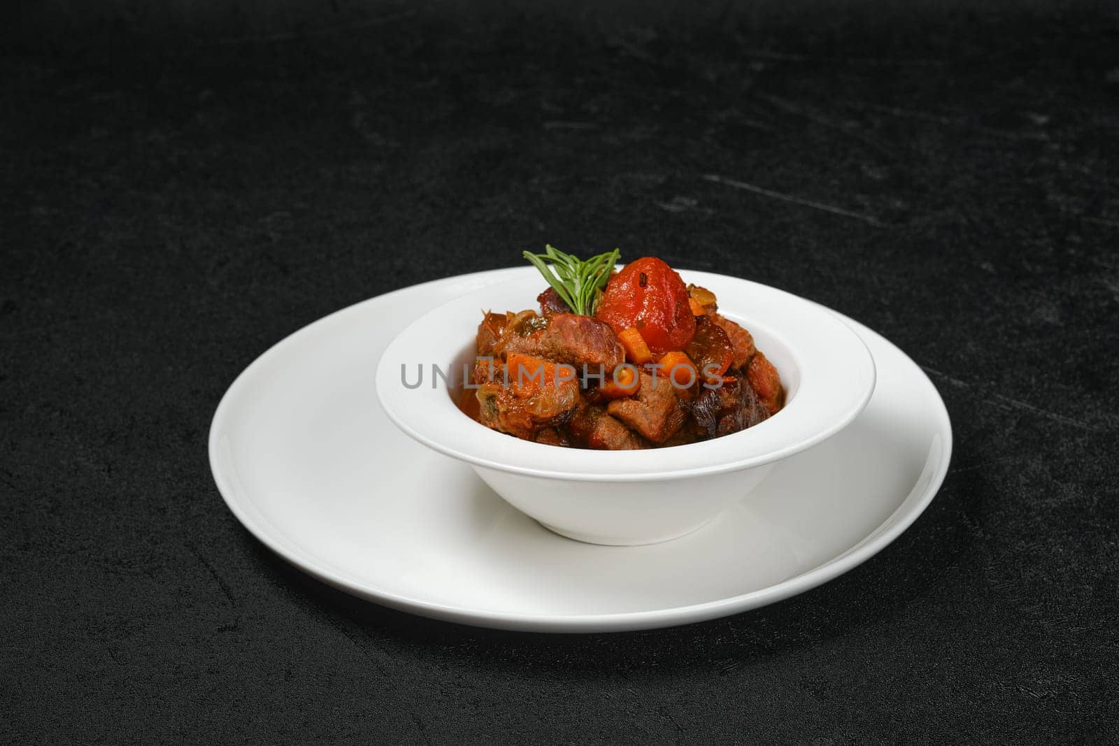 Beef stew with tomato on a plate