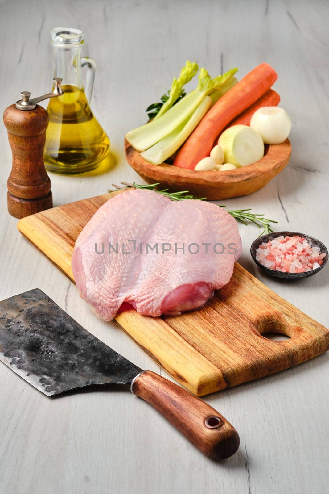Raw fresh whole chicken breast with skin on carcas with ingredients for cooking