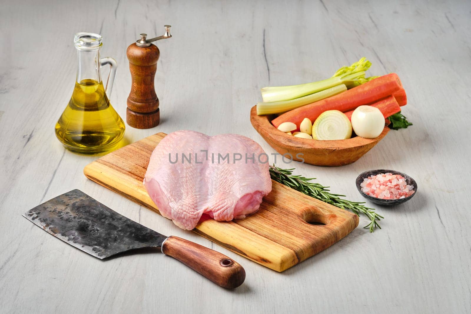 Raw fresh whole chicken breast with skin on carcas with ingredients for cooking