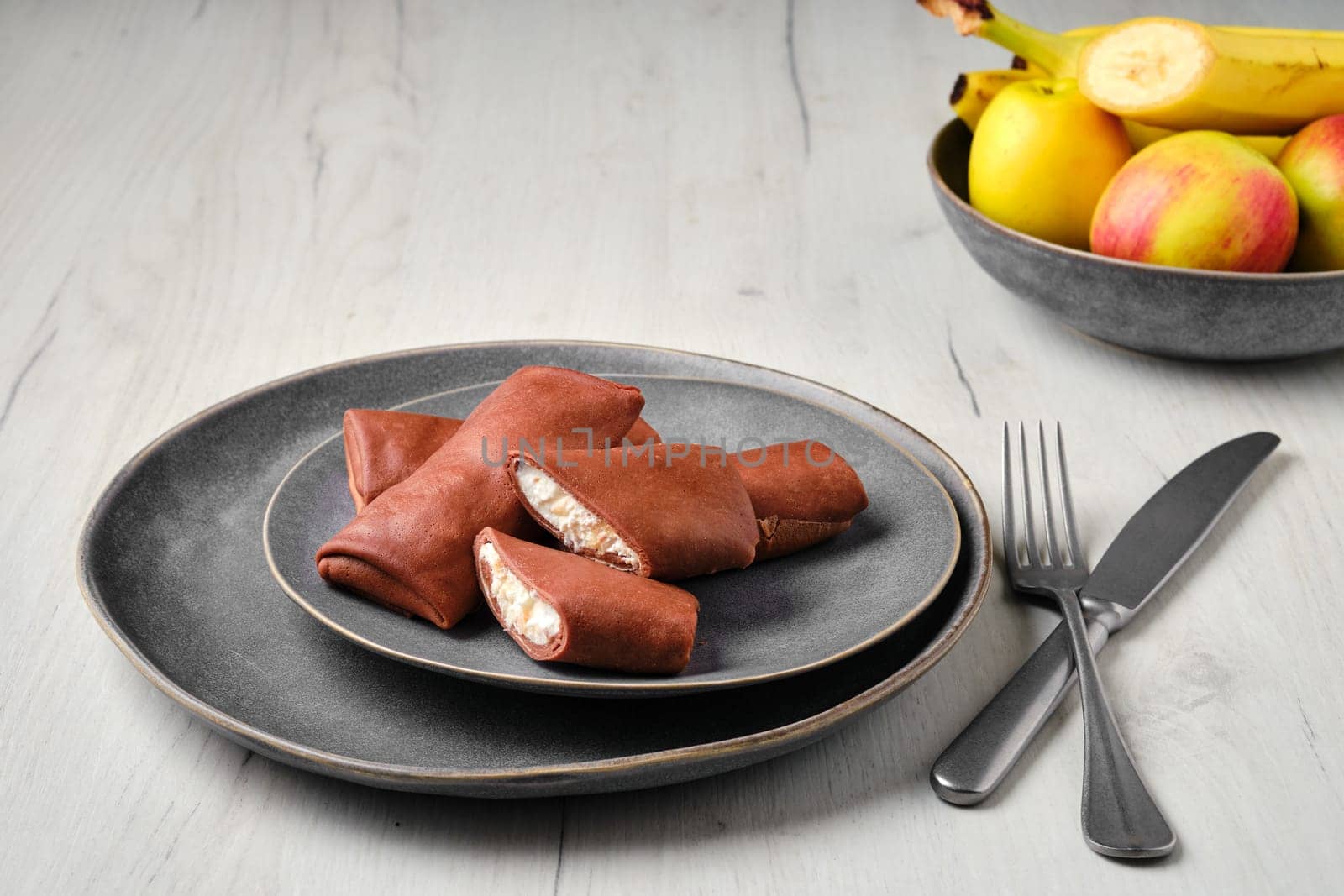 Thin chocolate pancakes stuffed with ricotta, banana and apple