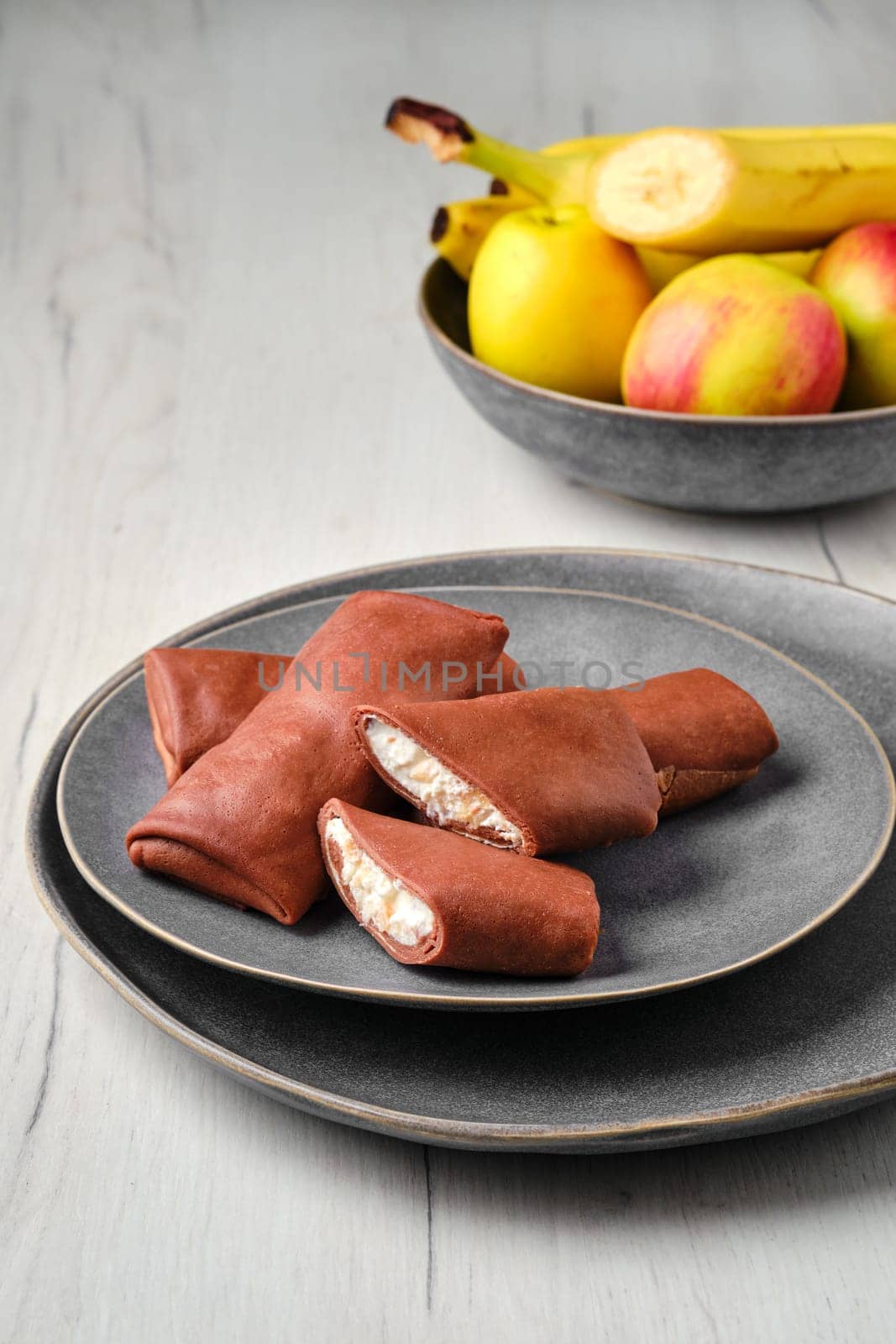 Thin chocolate pancakes stuffed with ricotta, banana and apple
