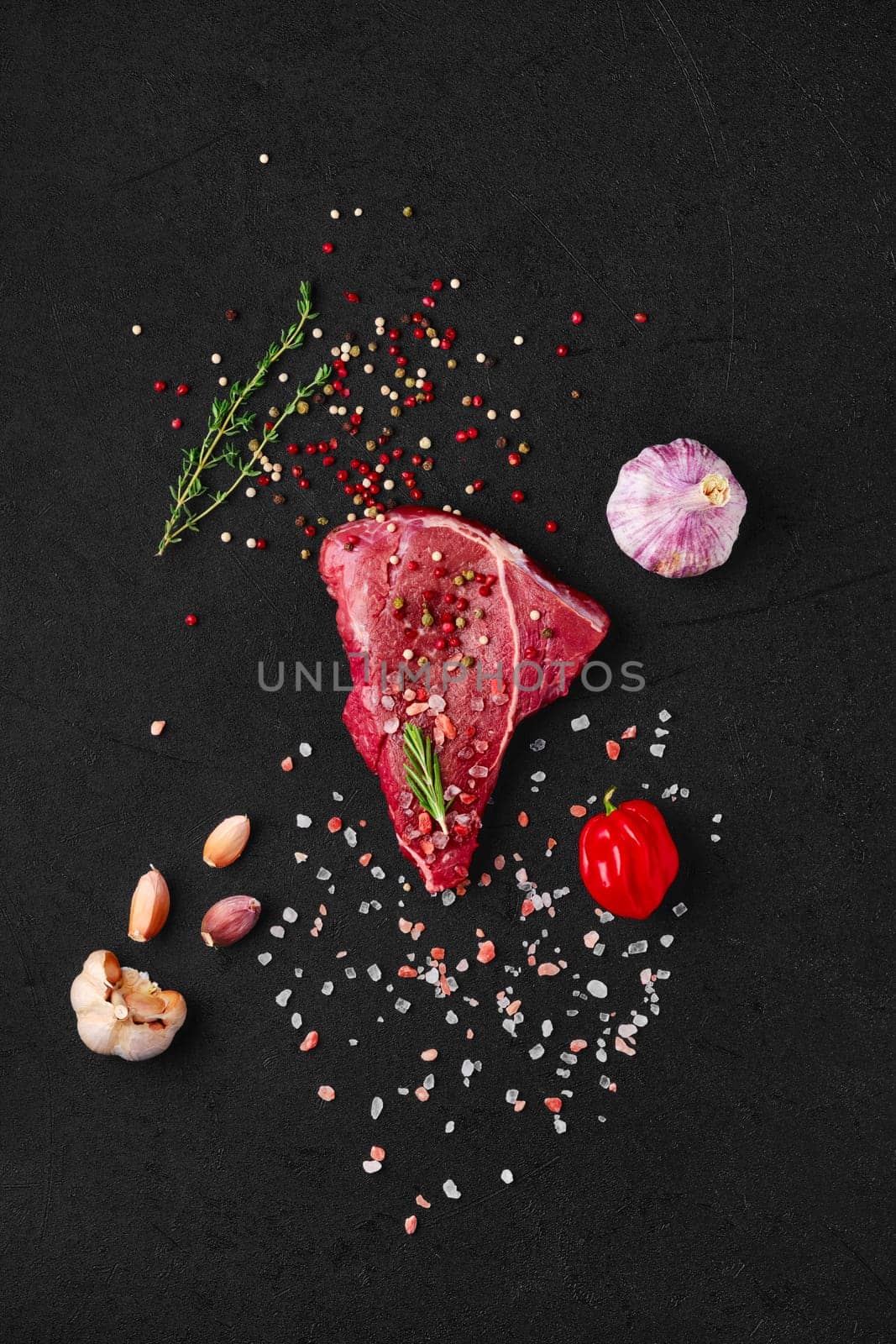 Overhead view of raw chuck eye steak with ingredients for cooking