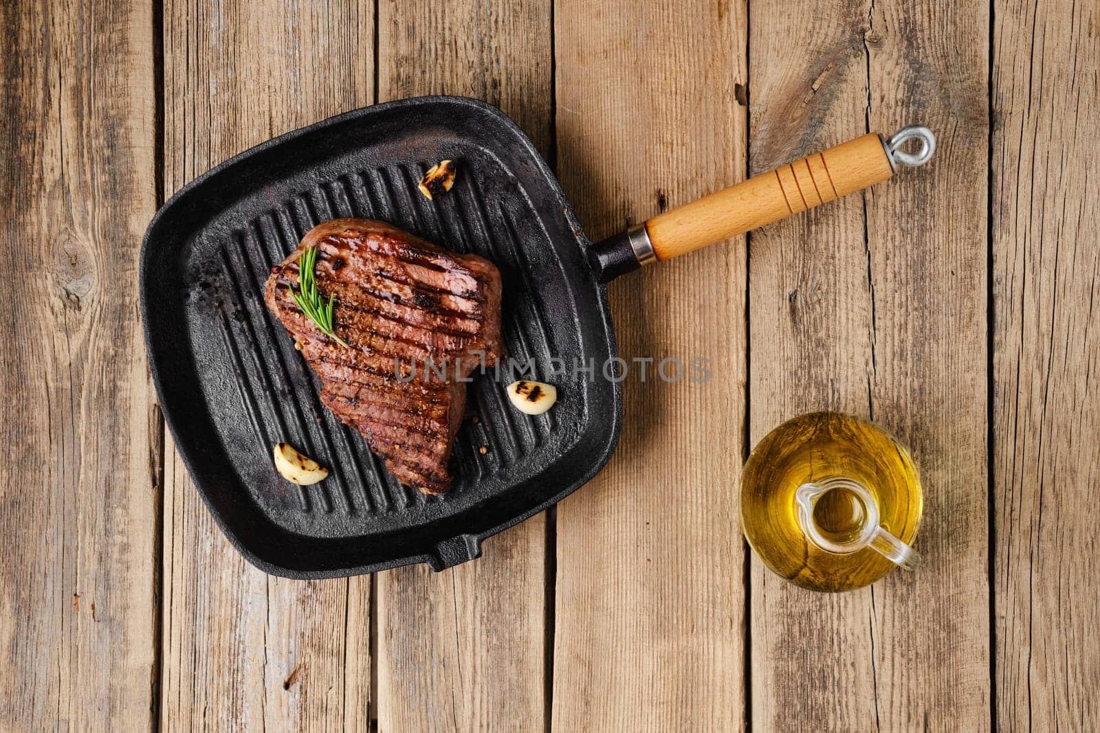 Overhead view of chuck eye steak fried on cast iron grill pan