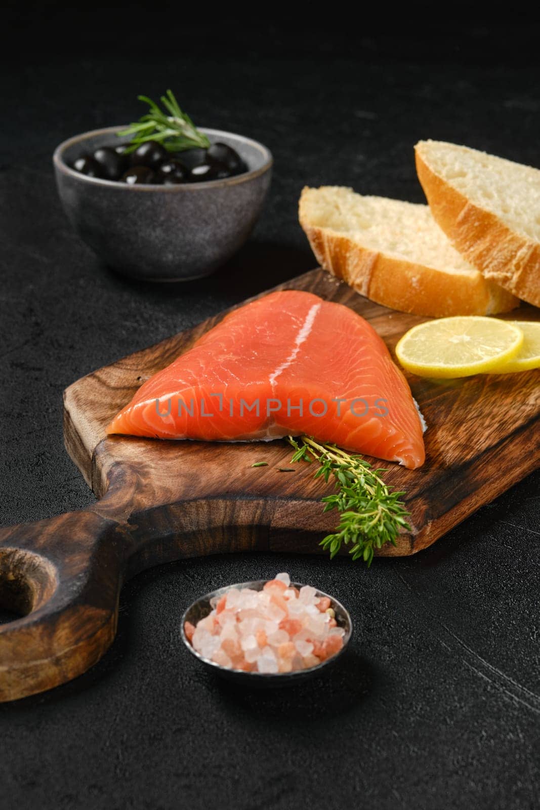 Piece of fresh salmon tail fillet with ciabatta and spicy herb sauce