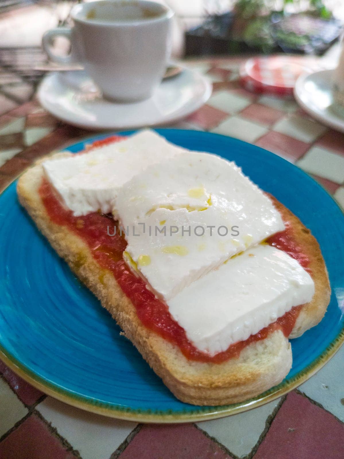 Cottage cheese and tomato toast over glazed tile mosaic table. Arabic style background