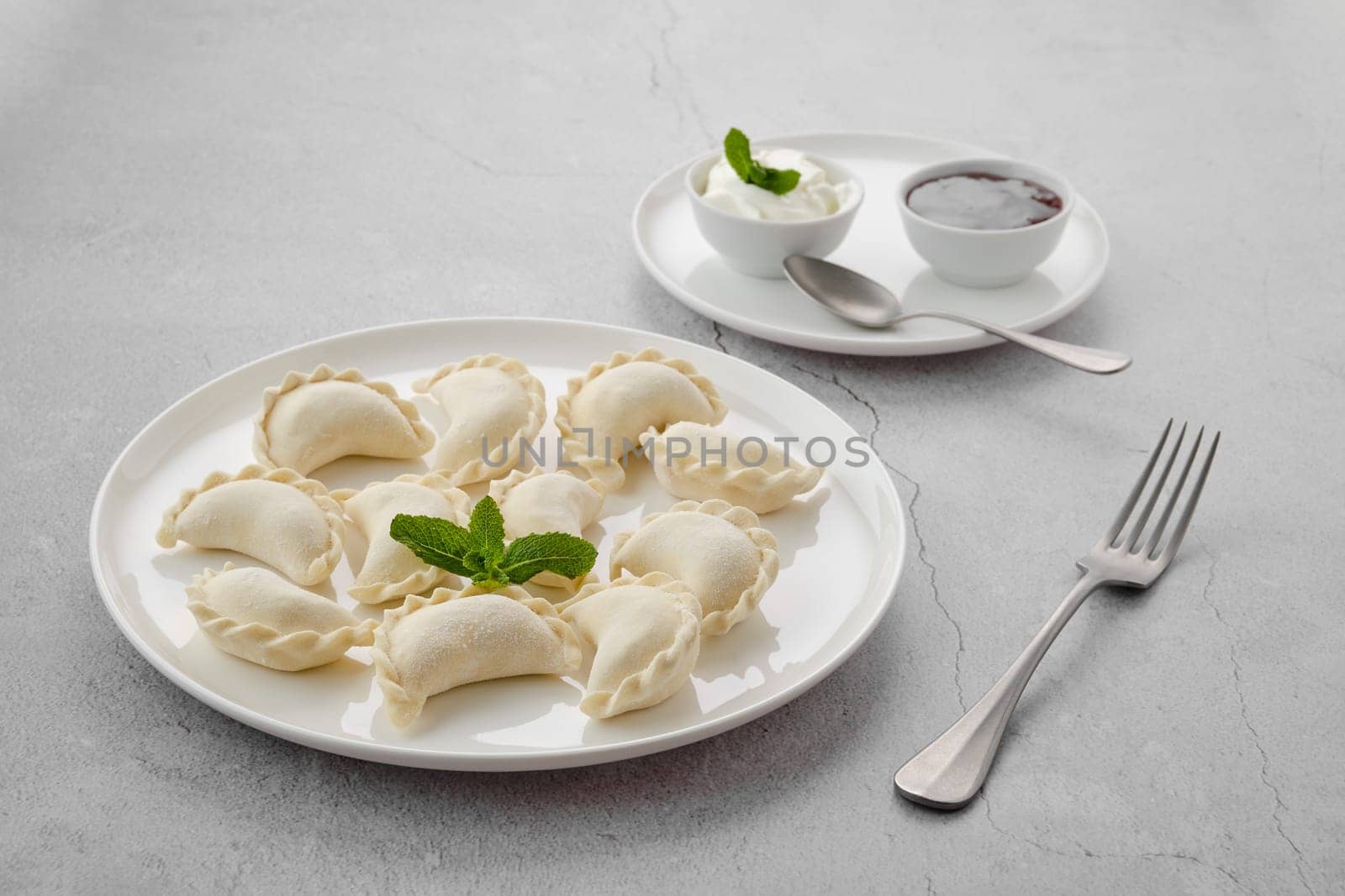 Frozen semifinished vareniki stuffed with cherry on grey background