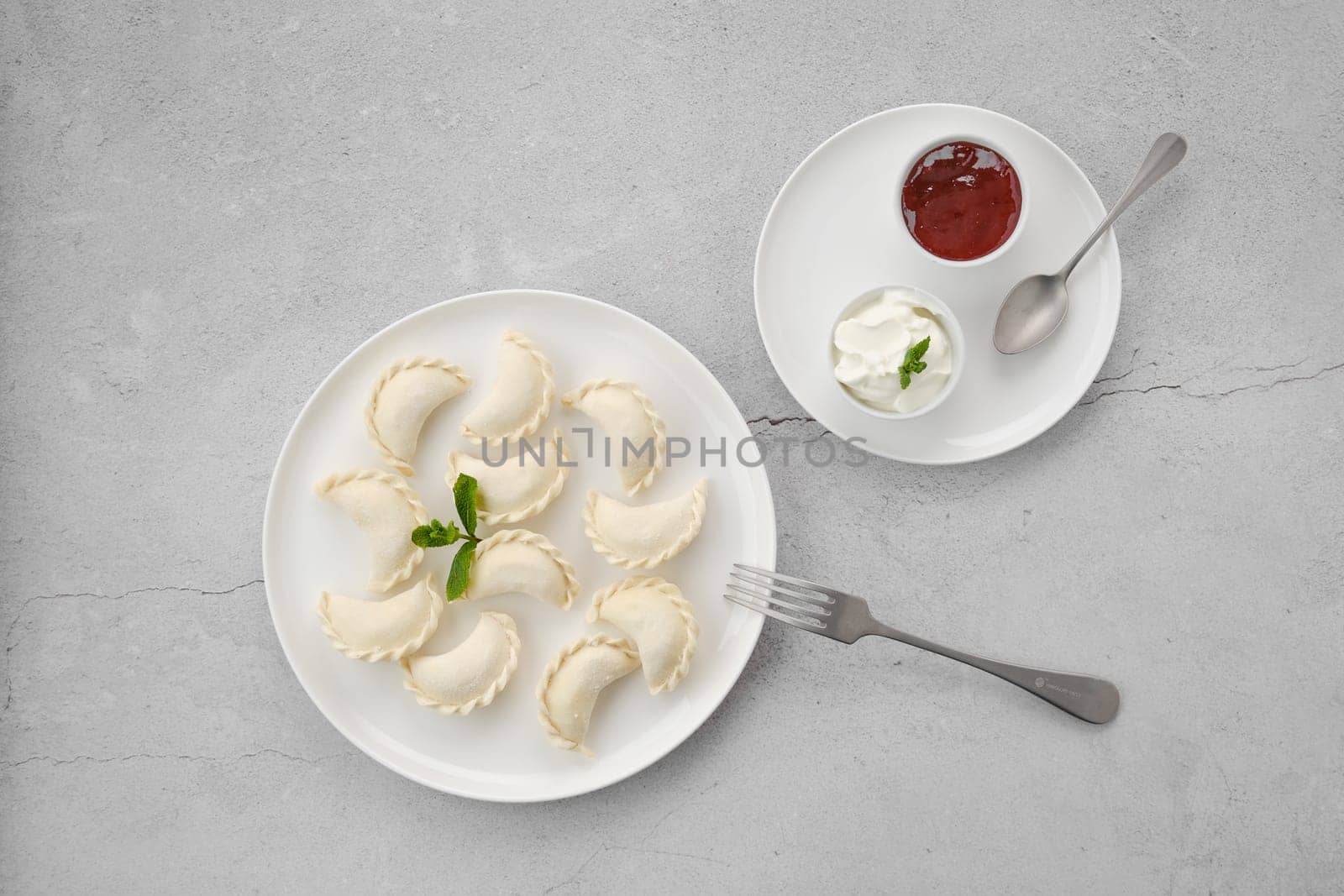 Frozen semifinished vareniki stuffed with cherry on grey background
