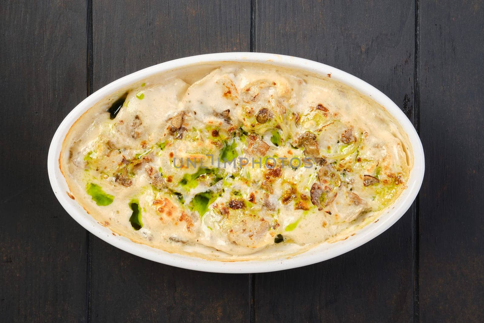 Overhead view of chicken dumplings with spicy onion sauce baked in oven