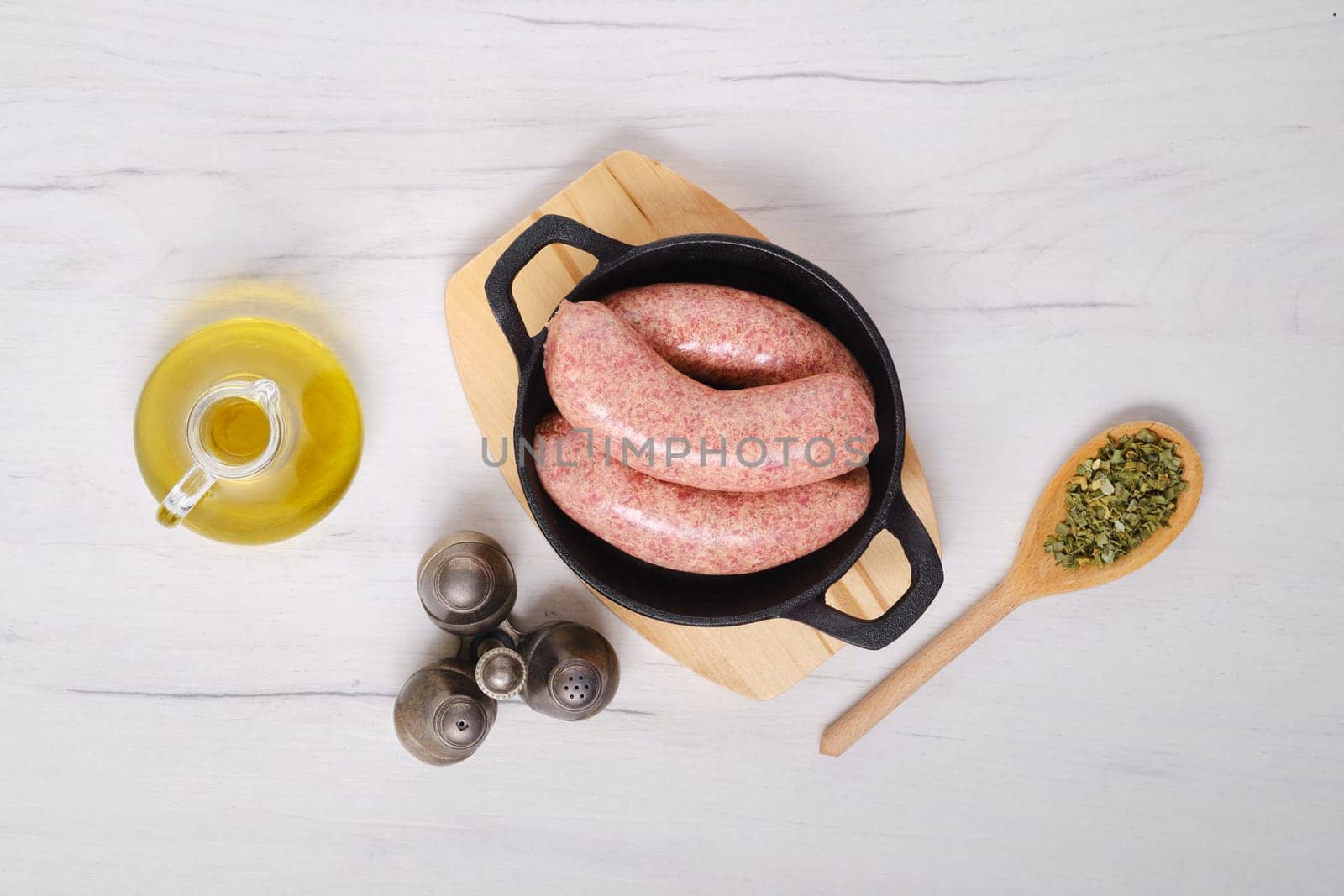 Top view of homemade classic raw beef sausage in cast iron skillet