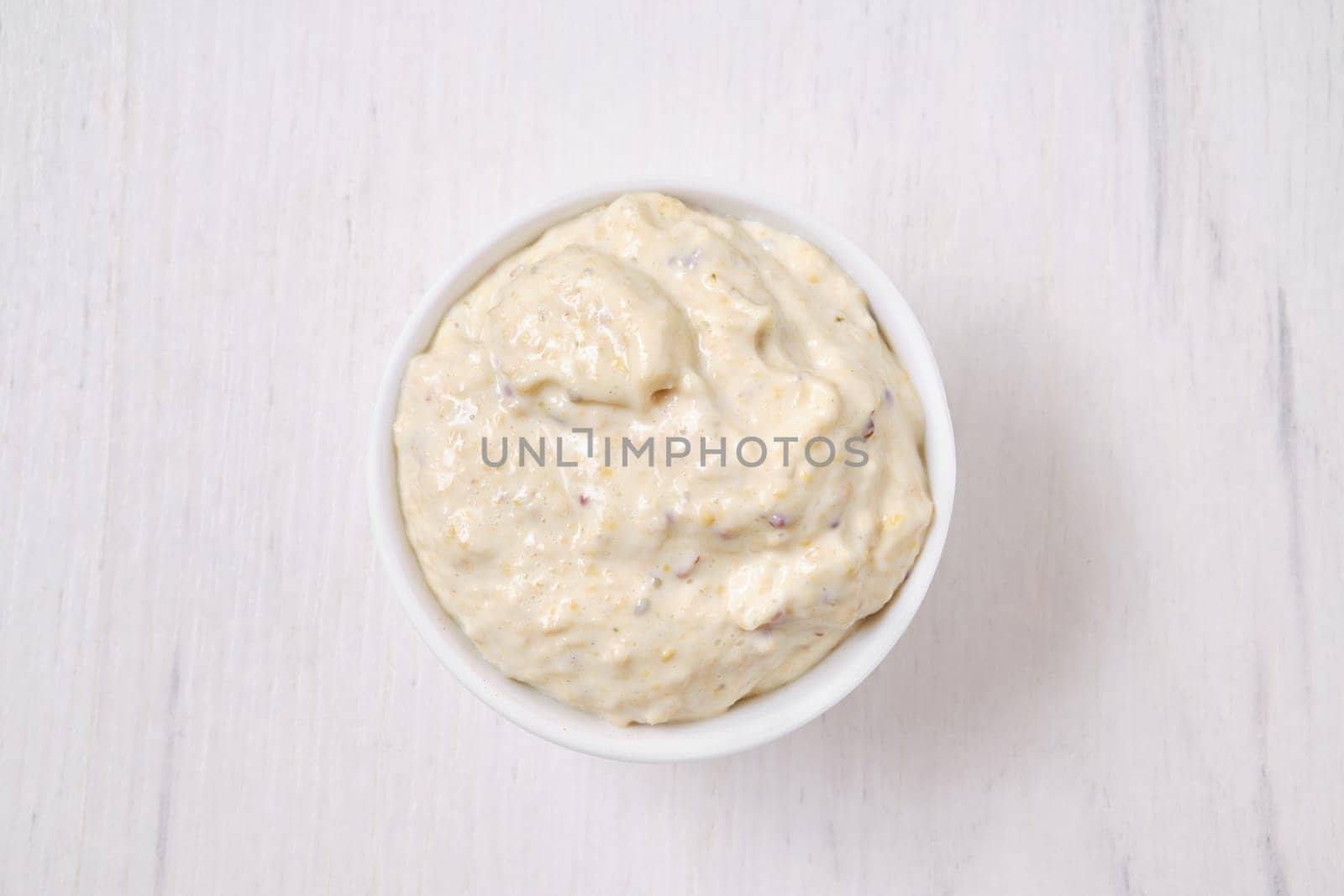 Overhead view of small bowl with caesar sauce for salad