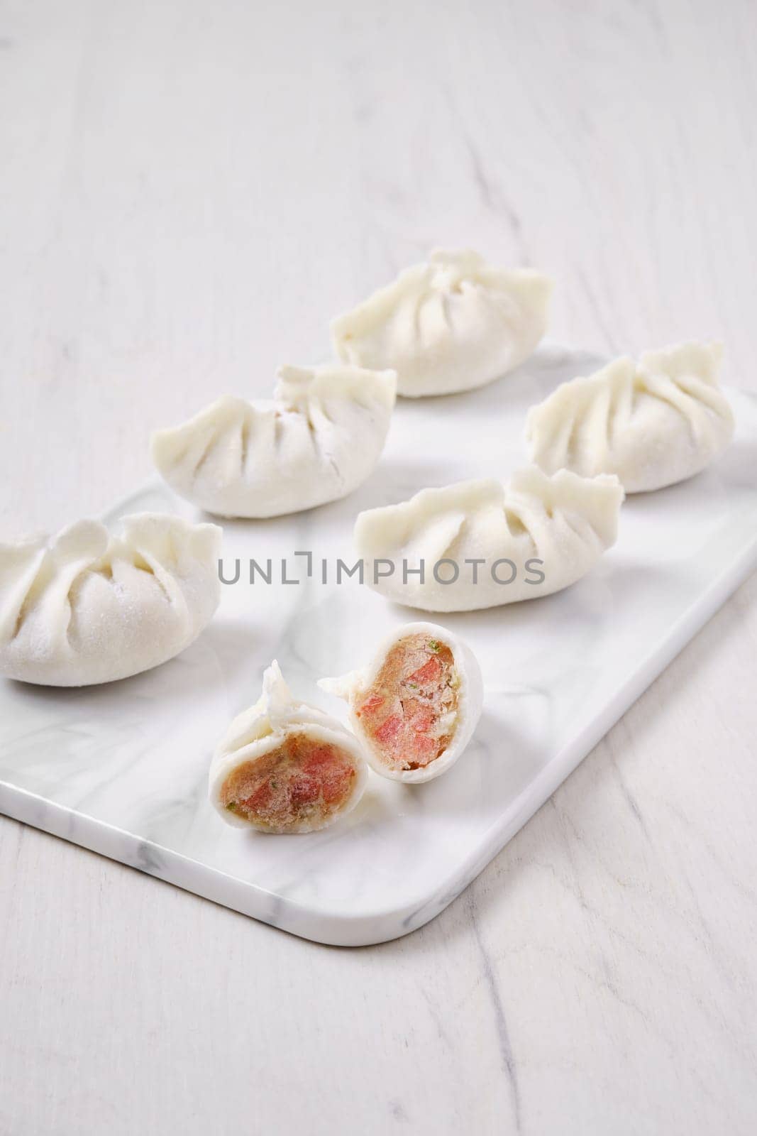Frozen dumplings stuffed with liver and provencal herbs on marble serving plate